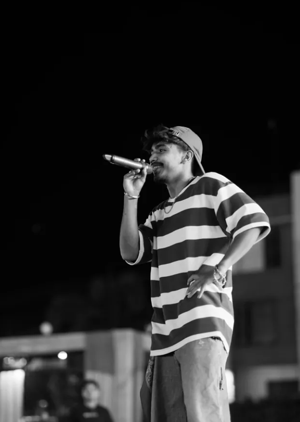 Tarun Bisht performing on stage under a spotlight